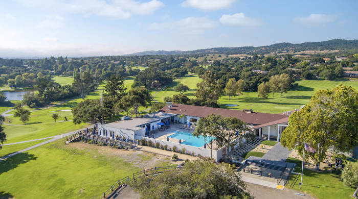 Beautiful landscaped walking path with greenery leading through a residential community with homes in the background.