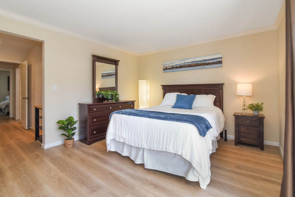 A cozy bedroom featuring a comfortable bed, wooden furniture, and warm lighting.