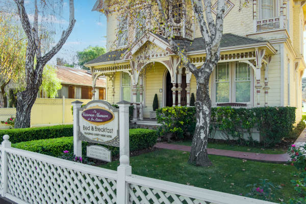 A serene backyard with a pool, dining area, and lush greenery.