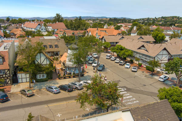 A serene backyard with a pool, dining area, and lush greenery.