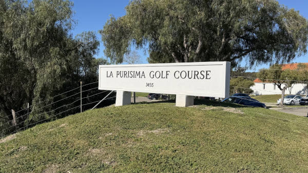View of a modern house exterior with a wooden deck and pergola.
